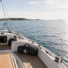 Wobbeltasche mit Logo auf dem Deck einer Segelyacht bei ruhigem Wasser und sonnigem Himmel am Meer