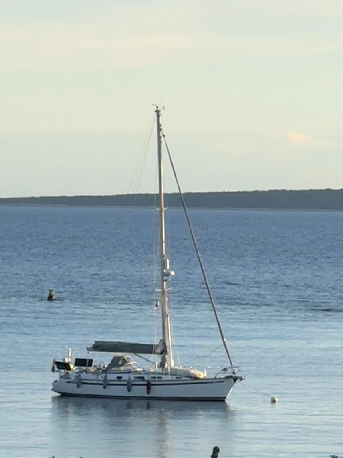 Segelyacht liegt ruhig vor Anker auf spiegelglattem Wasser